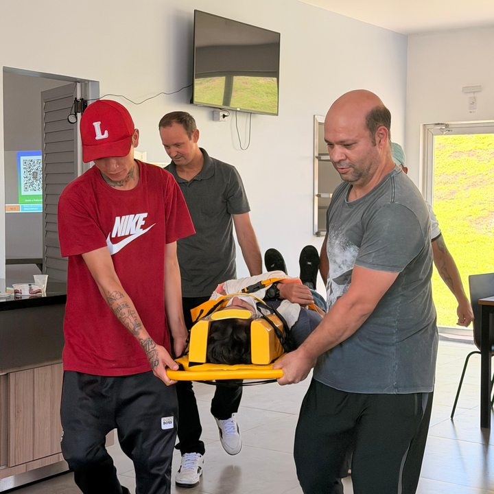 Equipe transportando vítima simulada em maca com colar cervical